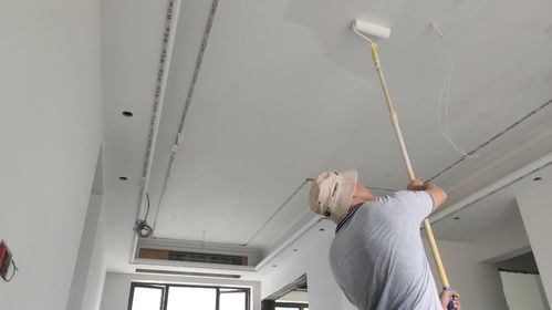 套房裝修施工現場,油漆工進行滾涂第一遍底漆